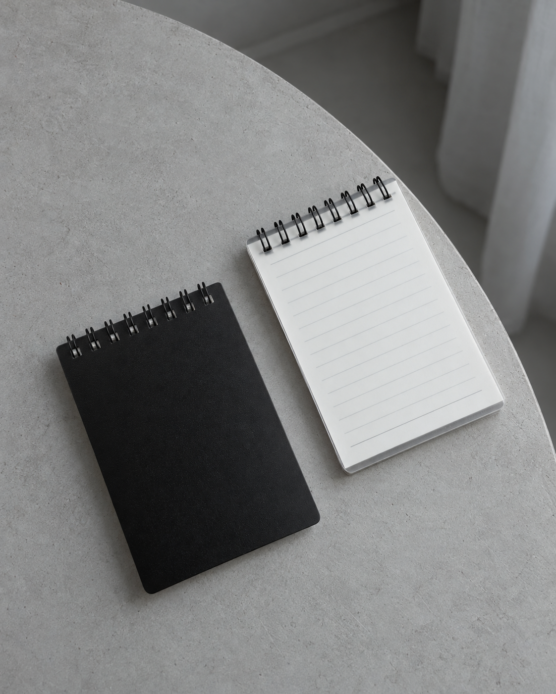 Black and transparent Business Notepads on a cool grey table