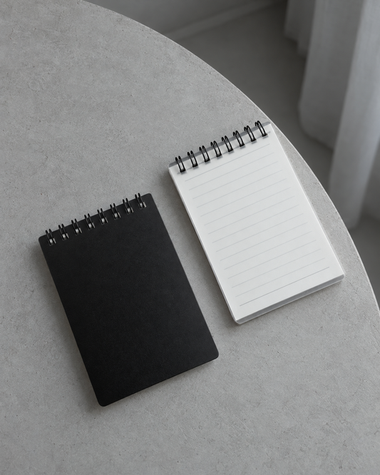 Black and transparent Business Notepads on a cool grey table
