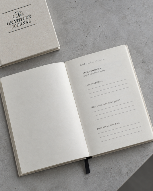 Cream Gratitude Journal open on a cool grey surface