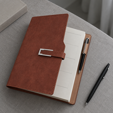Brown schedule notebook on cool grey linen